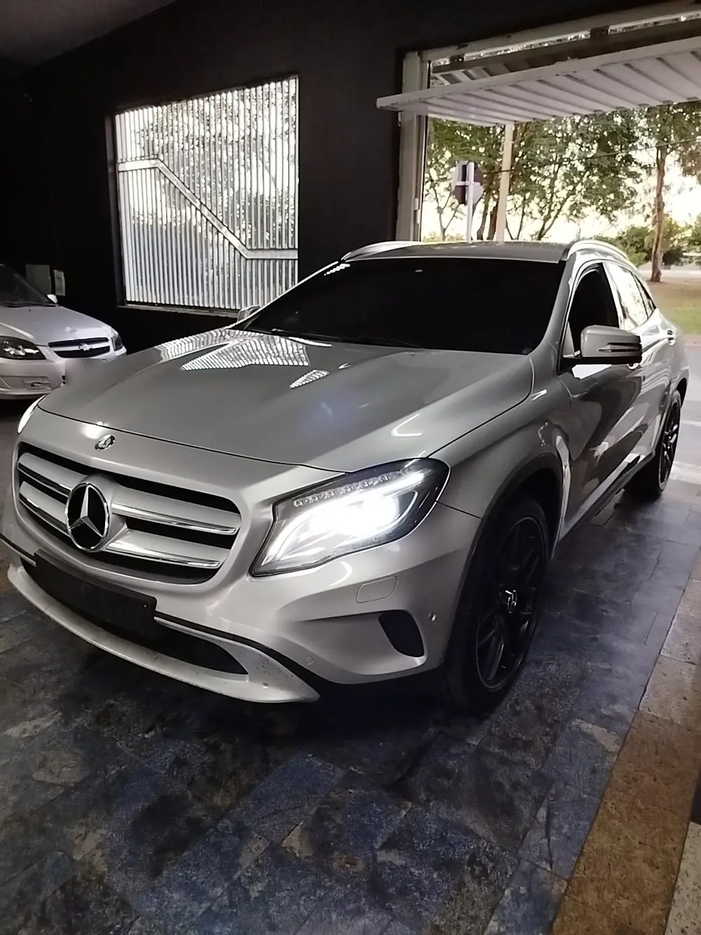 Mercedes GLA prata com faróis acesos dentro da Tokyo Car