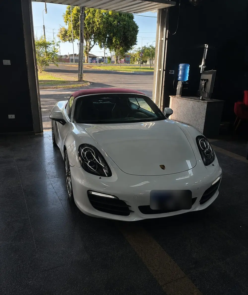 Porsche Boxster branco dentro da Tokyo Car, com o portão aberto