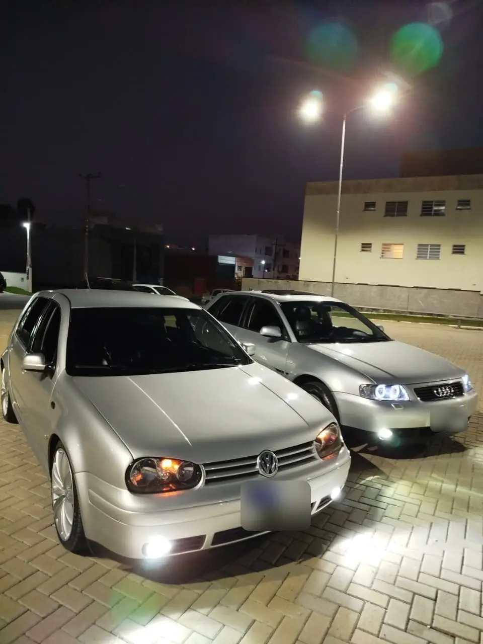 Golf e Audi A3 à noite com farol de LED aceso
